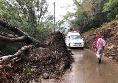 台風で被害を受けた道をゆく救護班